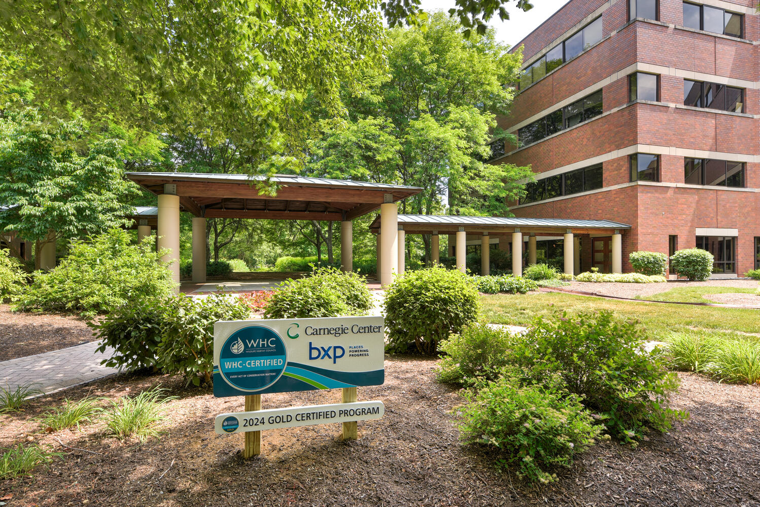 Outdoor space featuring signage for a Wildlife Habitat Council Certification award.