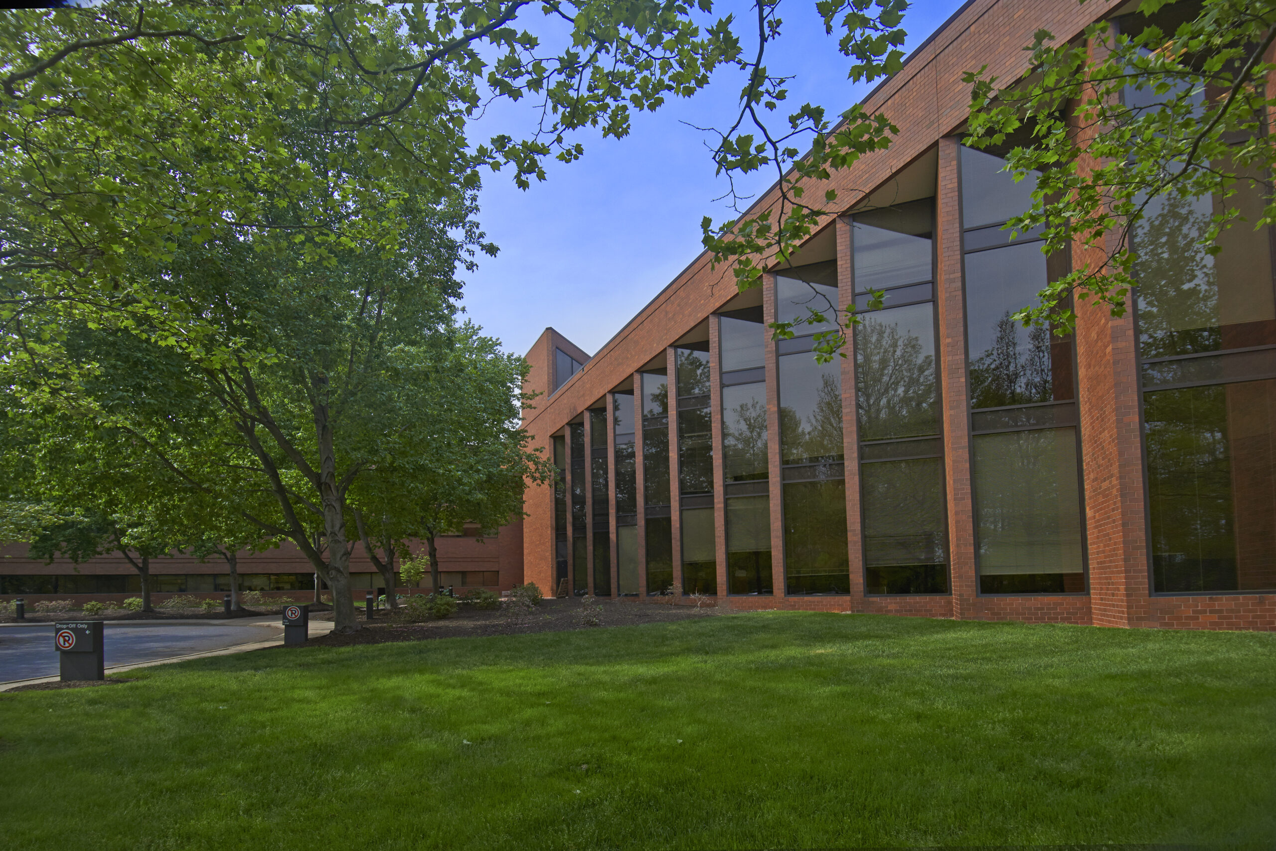 Exterior shot of an office building with tall windows and brick facade.