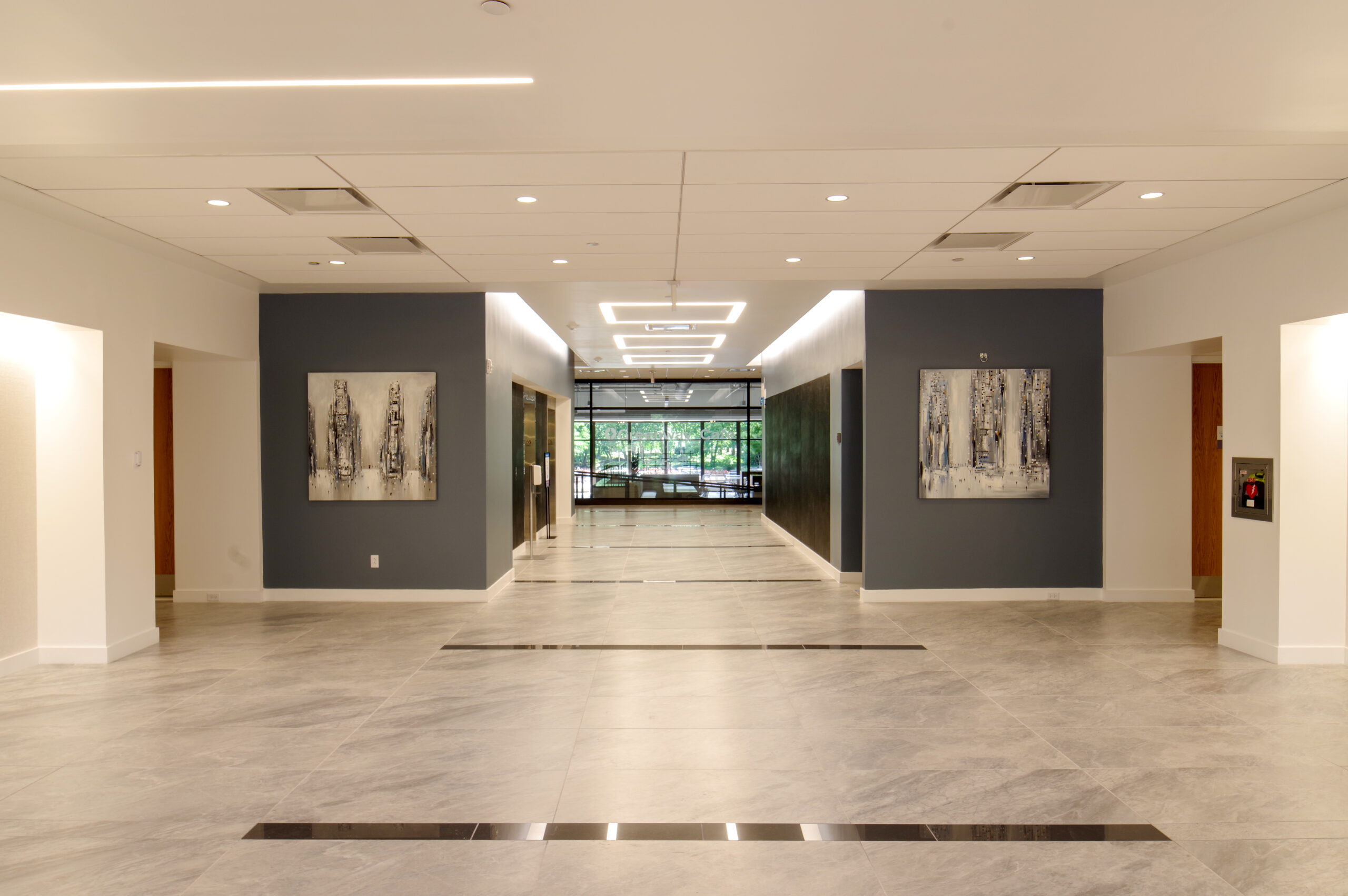 Interior shot of office building lobby with hallway to elevators.