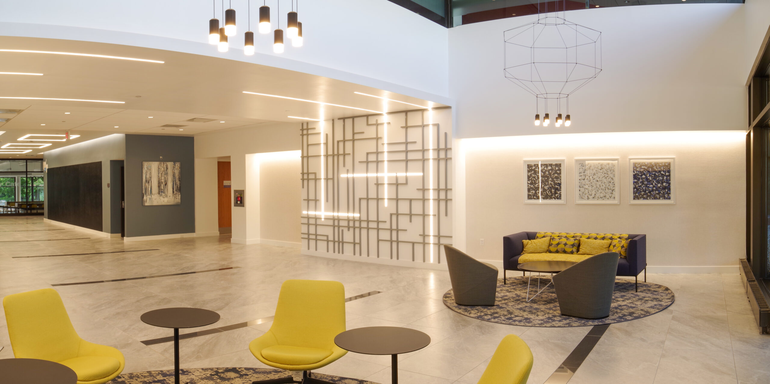 Interior shot of a building lobby with seating areas with pops of yellow.