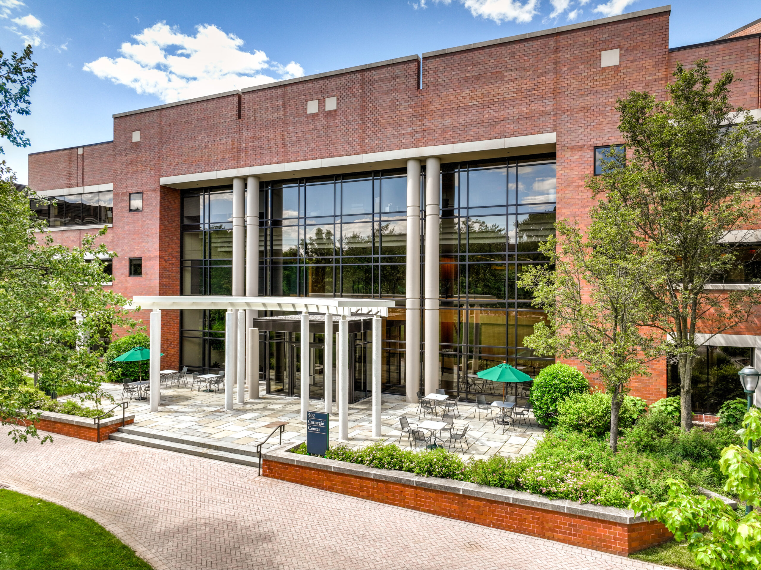 Exterior shot of a brick office building featuring a pergola on the patio.