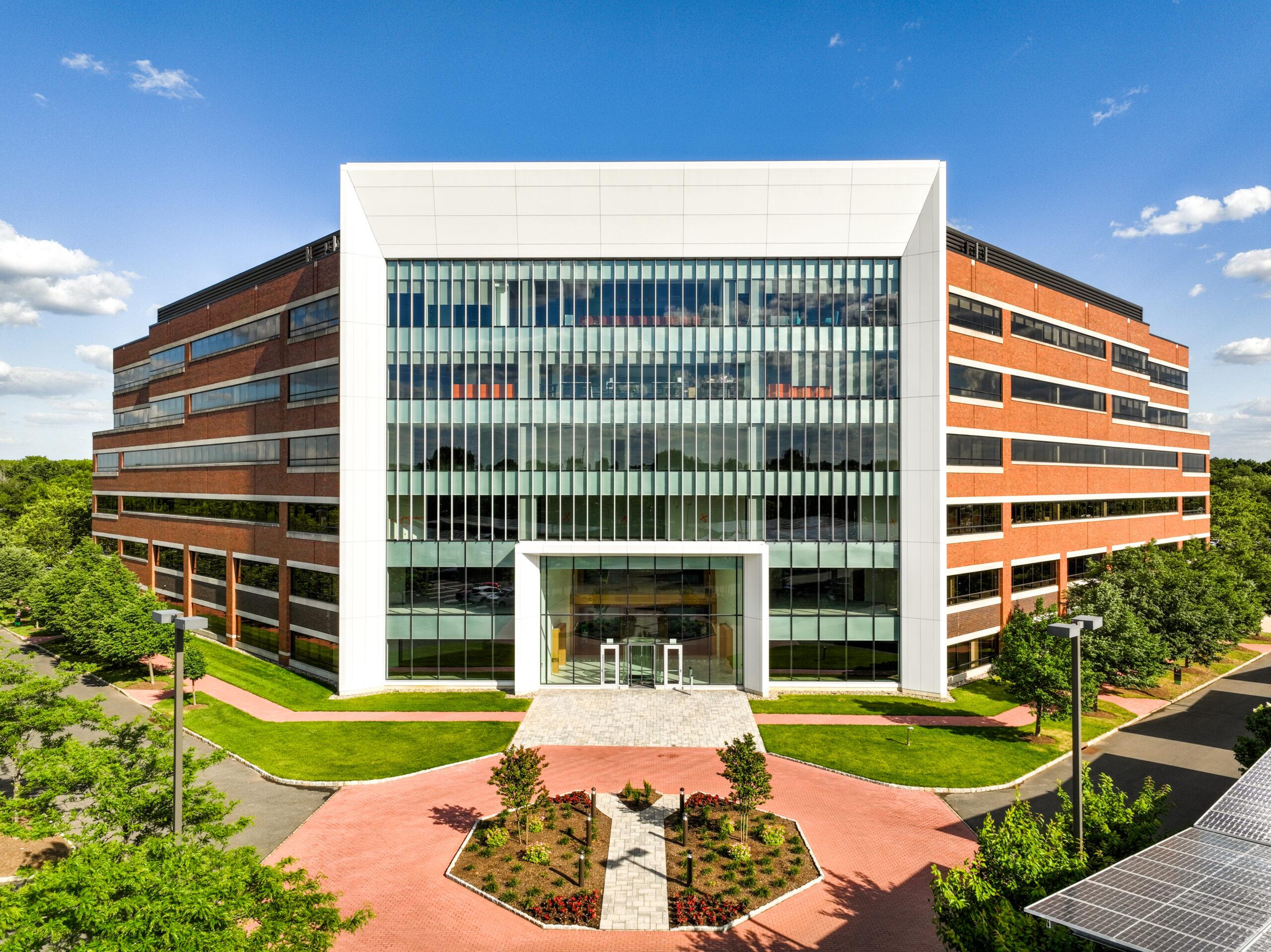 Exterior front elevation of a brick office building with a full glass front facade.